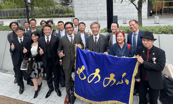 旗を囲んで集まる参加者