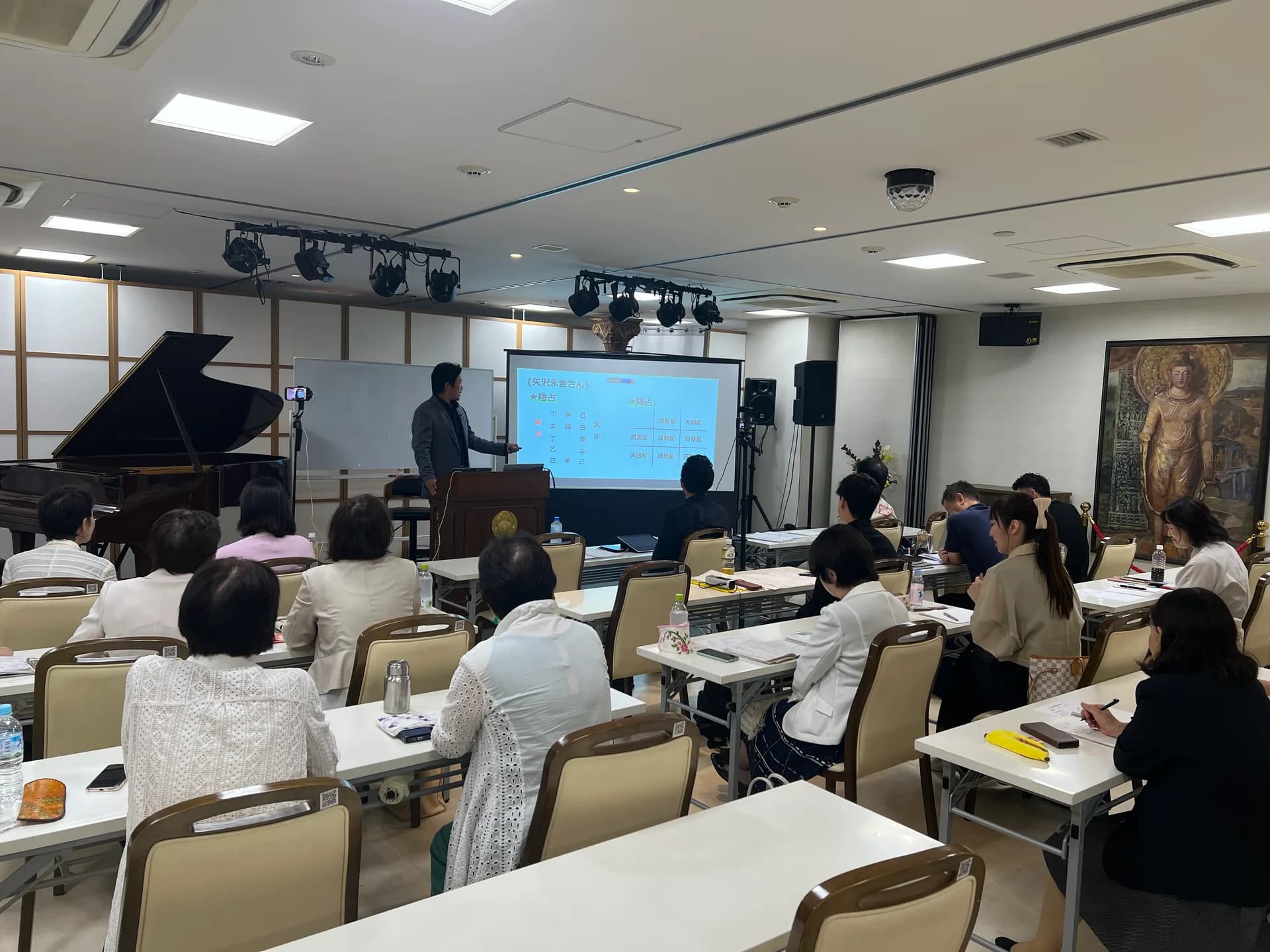 映像資料を使った講義と、会場で学ぶ参加者