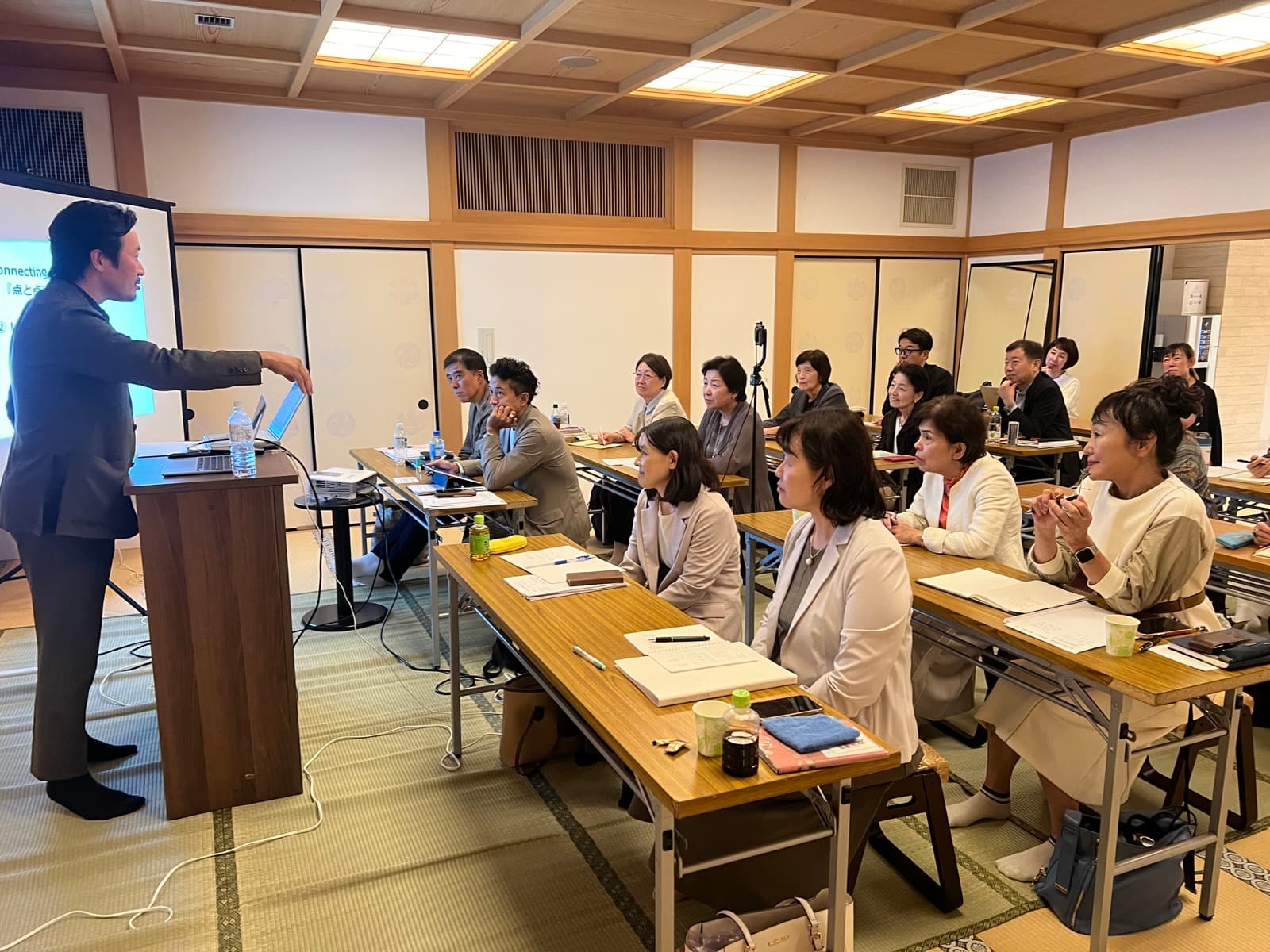 講師の話に耳を傾け、机に資料を広げて学ぶ参加者たち