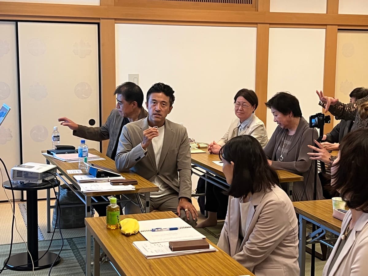 参加者がマイクを手に、周囲の仲間へ自分の考えを伝える様子